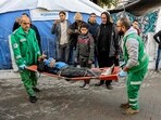 Palestinian Red Crescent paramedics transport on a gurney a person who was injured in a reported strike on a Palestinian civilian vehicle by Israeli forces, after arriving for medical care at the Ahli Arab Hospital in Gaza City on December 22, 2024.
