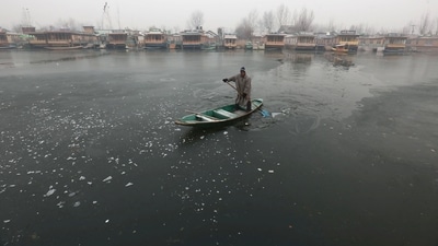 A boatman makes his way through partially frozen surface parts of Dal Lake in Srinagar, (Waseem Andrabi /Hindustan Times) A boatman makes his way through partially frozen surface parts of Dal Lake in Srinagar, (Waseem Andrabi /Hindustan Times)