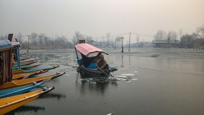 A boatman breaks the frozen surface parts of Dal Lake in Srinagar, (Waseem Andrabi /Hindustan Times)