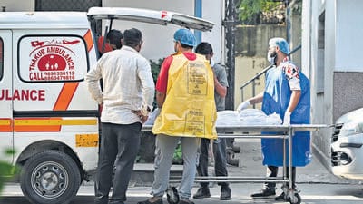 A mortuary staff person is wearing a plastic bag for biohazardous waste as a protective overall due to the lack of available protective gear. (Ajay Aggarwal/HT Photo) A mortuary staff person is wearing a plastic bag for biohazardous waste as a protective overall due to the lack of available protective gear. (Ajay Aggarwal/HT Photo)