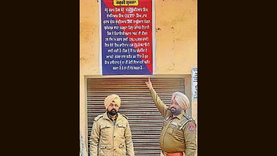 Cops after pasting notice on the wall of an accused. (HT Photo)