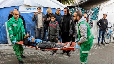 Palestinian Red Crescent paramedics transport on a gurney a person who was injured in a reported strike on a Palestinian civilian vehicle by Israeli forces, after arriving for medical care at the Ahli Arab Hospital in Gaza City on December 22, 2024. (AFP) Palestinian Red Crescent paramedics transport on a gurney a person who was injured in a reported strike on a Palestinian civilian vehicle by Israeli forces, after arriving for medical care at the Ahli Arab Hospital in Gaza City on December 22, 2024. (AFP)