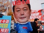 A protestor wears a cut-out of South Korean President Yoon Suk Yeol in a rally calling for his impeachment, who declared martial law, which was reversed hours later, near the National Assembly in Seoul, South Korea. (REUTERS)