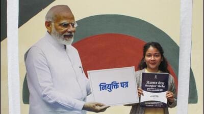 A newly-inducted recruit poses for photos with a cutout of PM Modi after receiving her appointment letter at a Rozgar Mela in Dehradun on Monday. (PTI) A newly-inducted recruit poses for photos with a cutout of PM Modi after receiving her appointment letter at a Rozgar Mela in Dehradun on Monday. (PTI)