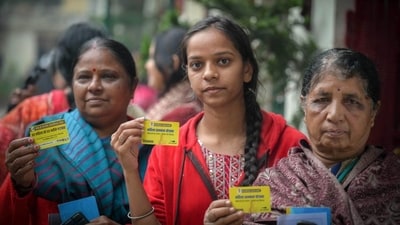 Beneficiaries in East Kidwai Nagar display their yellow cards that will allow them to avail of a monthly allowance of  ₹2,100. (RAJ K RAJ /HT PHOTO)