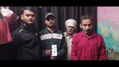 Brother holds photo of Abhishek Sharma with father (in red shirt). (HT) Brother holds photo of Abhishek Sharma with father (in red shirt). (HT)