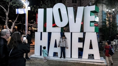A child poses for pictures before a giant "I love Haifa" installation in Israel's northern city of Haifa on December 21, 2024. (Photo by AHMAD GHARABLI / AFP) (AFP) A child poses for pictures before a giant "I love Haifa" installation in Israel's northern city of Haifa on December 21, 2024. (Photo by AHMAD GHARABLI / AFP) (AFP)