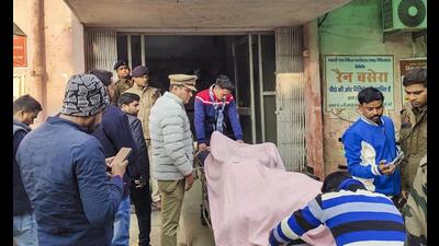 Police personnel and others stand near the body of one of the three terror suspects who were killed in an encounter with a joint team of Uttar Pradesh and Punjab police, at a hospital, in Pilibhit, Monday. (PTI Photo)