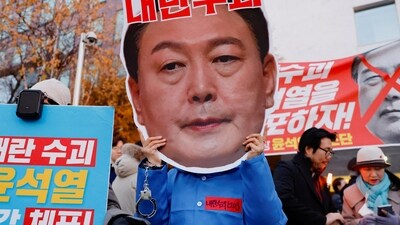 A protestor wears a cut-out of South Korean President Yoon Suk Yeol in a rally calling for his impeachment, who declared martial law, which was reversed hours later, near the National Assembly in Seoul, South Korea. (REUTERS)