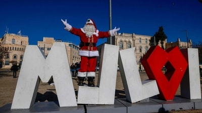 Palestinian Issa Kassissieh, dressed as Santa Claus, poses for a photo at Jaffa Gate in Jerusalem's Old City. (AFP) Palestinian Issa Kassissieh, dressed as Santa Claus, poses for a photo at Jaffa Gate in Jerusalem's Old City. (AFP)