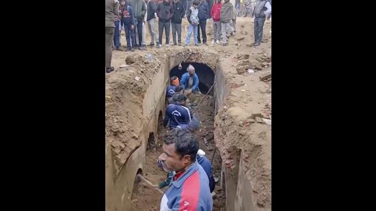 Workers at the site after an ancient well closed for a long time with clean water was discovered in Sambhal, Monday. (PTI Photo)