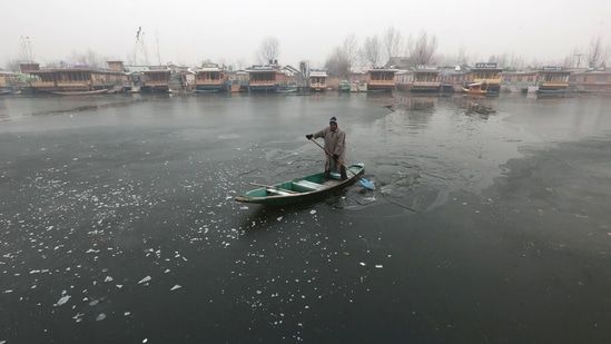 A boatman makes his way through partially frozen surface parts of Dal Lake in Srinagar,on 21 December 2024. Kashmir is in the grip of a cold wave and the 40-day period of Chillai Kalan (major cold) began in the Valley on an icy note with Srinagar witnessing temperatures of -8.5 degrees Celsius, the coldest in 34 years for the same period. All other parts of Kashmir also witnessed sub-zero temperatures. (Waseem Andrabi /Hindustan Times)