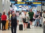 An American Airlines employee wearing a Santa Claus hat walks through the American terminal at Miami International Airport, on Christmas Eve, Tuesday, Dec. 24, 2024, in Miami.  (AP Photo/Rebecca Blackwell)