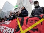 Protesters hold a banner showing images of impeached president Yoon Suk Yeol and acting President Han Duck-soo