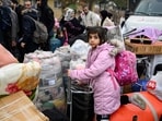 Syrian refugees living in Turkey wait in a queue to enter Syria