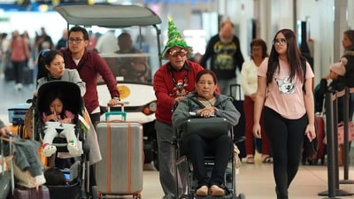 American Airlines partner's worker providing wheelchair assistance, to a traveler at Miami International Airport, on Christmas Eve, Tuesday, Dec. 24, 2024, in Miami. (AP Photo/Rebecca Blackwell) (AP) American Airlines partner's worker providing wheelchair assistance, to a traveler at Miami International Airport, on Christmas Eve, Tuesday, Dec. 24, 2024, in Miami. (AP Photo/Rebecca Blackwell) (AP)