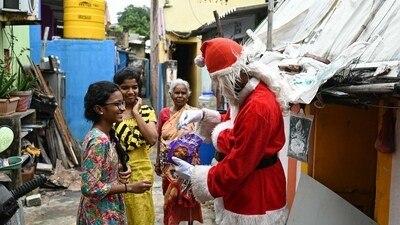 A man dressed in a Santa Claus outfit was seen offering chocolates to children in Chennai, in the holiday spirit. (AFP) A man dressed in a Santa Claus outfit was seen offering chocolates to children in Chennai, in the holiday spirit. (AFP)