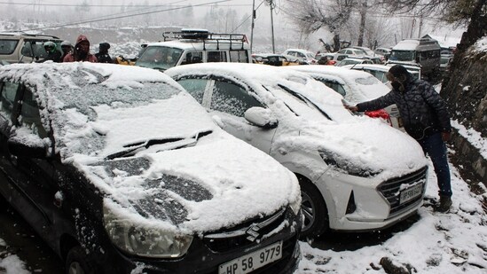 At Manali in Himachal Pradesh's Kullu district, a man was spotted clearing snow off his car after fresh snowfall on Tuesday. The meteorological department issued an 'orange' warning for extreme cold in Bilaspur, Una, Hamirpur, and Mandi and a 'yellow' warning for dense fog in parts of the Bhakra Dam area and Balh Valley in Mandi until Thursday.(ANI)