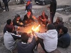 People sit around a bonfire to warm themselves on a winter evening, in New Delhi, Tuesday, Dec. 24, 2024. 