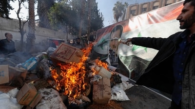 A banner with an image depicting the ousted Syrian President Bashar Assad is placed on the fire as a Syrian member of the rebel forces destroys drugs and alcoholic beverages, found at a complex building in Damascus, Syria, Wednesday, (AP) A banner with an image depicting the ousted Syrian President Bashar Assad is placed on the fire as a Syrian member of the rebel forces destroys drugs and alcoholic beverages, found at a complex building in Damascus, Syria, Wednesday, (AP)