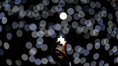 A Christian devotee holds a candle on Christmas eve, at Indonesia Arena in Jakarta. (AFP)