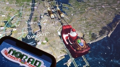 (FILES) This illustration photo shows the NORAD logo on a cell phone screen while the tracker follows Santa flying over New York City on a computer monitor in Los Angeles on December 24, 2023. (AFP) (FILES) This illustration photo shows the NORAD logo on a cell phone screen while the tracker follows Santa flying over New York City on a computer monitor in Los Angeles on December 24, 2023. (AFP)