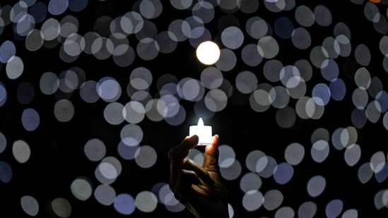 A Christian devotee holds a candle on Christmas eve, at Indonesia Arena in Jakarta.(AFP)