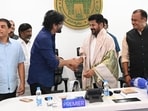 Nagarjuna drapes Telangana CM Revanth Reddy in a shawl and shakes his hand.