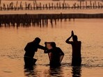 Pilgrims take a dip along the banks of Sangam, the confluence of Ganges, Yamuna and mythical Saraswati rivers, ahead of the Maha Kumbh Mela festival in Prayagraj on December 22, 2024. 