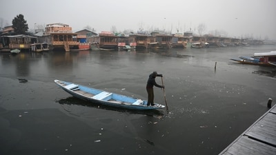 A boatman makes his way through the frozen surface of Dal Lake on a cold morning in Srinagar on December 25, 2024. (Waseem Andrabi/Hindustan Times)--) A boatman makes his way through the frozen surface of Dal Lake on a cold morning in Srinagar on December 25, 2024. (Waseem Andrabi/Hindustan Times)--)
