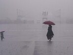 People move amid rain at Vijay Chowk, in New Delhi. People move amid rain at Vijay Chowk, in New Delhi.