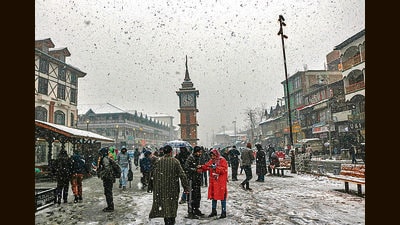 People enjoying at Lal Chowk during first snowfall of the season in Srinagar on Friday. (Waseem Andrabi /HT) People enjoying at Lal Chowk during first snowfall of the season in Srinagar on Friday. (Waseem Andrabi /HT)