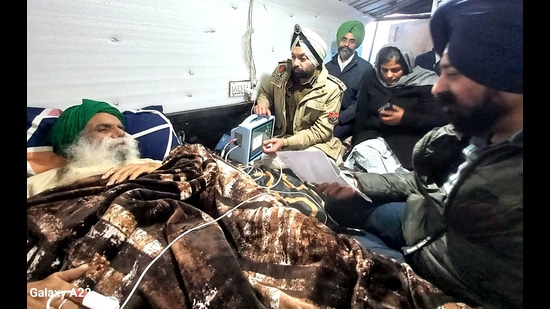 Police officials meet farmer leader Jagjit Singh Dallewal who is fasting unto death and appealed to him to take care of his health, at the Khanauri border near Patiala on Friday. (ANI)