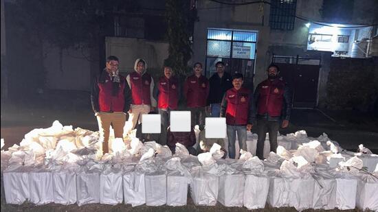 Police with the accused and seized contraband. (HT Photo)