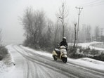Vehicles ply during the first snowfall of the season in Srinagar on December 27
Vehicles ply during the first snowfall of the season in Srinagar on December 27