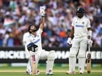 India's Nitish Kumar Reddy celebrates his century as Mohammed Siraj looks on.