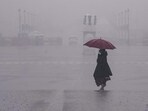 People move amid rain at Vijay Chowk, in New Delhi on Friday, People move amid rain at Vijay Chowk, in New Delhi on Friday,