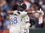 India's Nitish Kumar Reddy (L) celebrates with Mohammed Siraj after passing 100 on day three of the fourth cricket Test match against Australia.