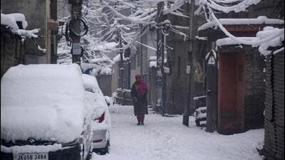 A woman walking on a snow-covered street in Srinagar on Saturday. Heavy snowfall blocked the Srinagar-Jammu national highway and roads in several districts. (PTI Photo) A woman walking on a snow-covered street in Srinagar on Saturday. Heavy snowfall blocked the Srinagar-Jammu national highway and roads in several districts. (PTI Photo)