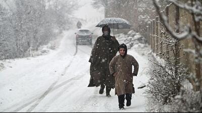 People walking on a road during the first snowfall of the season in Srinagar on Friday. (Waseem Andrabi/HT) People walking on a road during the first snowfall of the season in Srinagar on Friday. (Waseem Andrabi/HT)