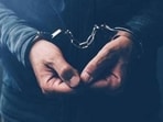 Arrested computer hacker and cyber criminal with handcuffs, close up of hands