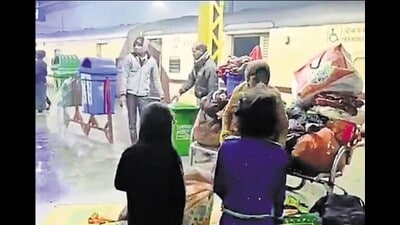 A grab from the video from Charbagh station where sanitation workers were seen splashing water. The passengers including children and women were seen gathering their belongings. (HT) A grab from the video from Charbagh station where sanitation workers were seen splashing water. The passengers including children and women were seen gathering their belongings. (HT)