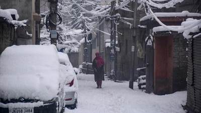 A woman walking on a snow-covered street in Srinagar on Saturday. Heavy snowfall blocked the Srinagar-Jammu national highway and roads in several districts. (PTI Photo) A woman walking on a snow-covered street in Srinagar on Saturday. Heavy snowfall blocked the Srinagar-Jammu national highway and roads in several districts. (PTI Photo)