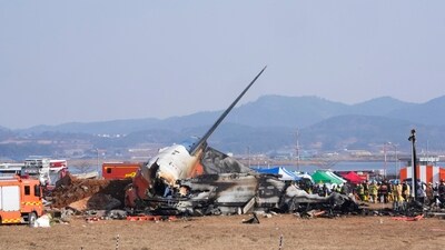 Firefighters and rescue team members work near the wreckage of a passenger plane at Muan International Airport in Muan. (AP) Firefighters and rescue team members work near the wreckage of a passenger plane at Muan International Airport in Muan. (AP)