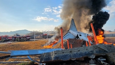 Fire and smoke rise from the tail section of a Jeju Air Boeing 7C2216 aircraft after the plane crashed and burst into flames at Muan International Airport. (AFP) Fire and smoke rise from the tail section of a Jeju Air Boeing 7C2216 aircraft after the plane crashed and burst into flames at Muan International Airport. (AFP)