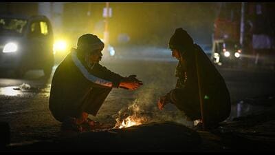 Two people sit around a bonfire to stave off the cold. (Sanchit Khanna/HT Photo) Two people sit around a bonfire to stave off the cold. (Sanchit Khanna/HT Photo)