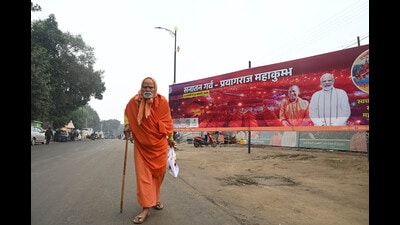 A seer moves past a poster at Mahakumbh Nagar in Prayagraj. (Deepak Gupta/HT) A seer moves past a poster at Mahakumbh Nagar in Prayagraj. (Deepak Gupta/HT)