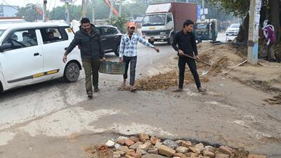 A traffic police constable repairs potholes between Umang Bhardwaj Chowk and Hero Honda Chowk near Sector 37 on Monday. (Parveen Kumar/HT Photo) A traffic police constable repairs potholes between Umang Bhardwaj Chowk and Hero Honda Chowk near Sector 37 on Monday. (Parveen Kumar/HT Photo)