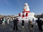 People taking a picture with a snowman sculpture in Harbin, China's Northeastern Heilongjiang province. People taking a picture with a snowman sculpture in Harbin, China's Northeastern Heilongjiang province.