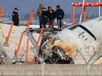 Investigators, including officials from South Korea's Aviation and Railway Accident Investigation Board (ARAIB), US National Transportation Safety Board (NTSB) and aircraft manufacturer Boeing, stand by the mound where the instrument landing system localiser is located, at the scene where a Jeju Air Boeing 737-800 aircraft crashed and burst into flames at Muan International Airport.